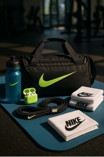 A high-quality studio flat-lay of a Nike gym bag, water bottle, resistance band, and towels, capturing an aspirational fitness lifestyle.
